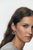 Close-up of a woman wearing star-shaped earrings with a plain background. Star of David cubic zirconia earrings by Bande de Vagabonds – mindful holiday jewelry